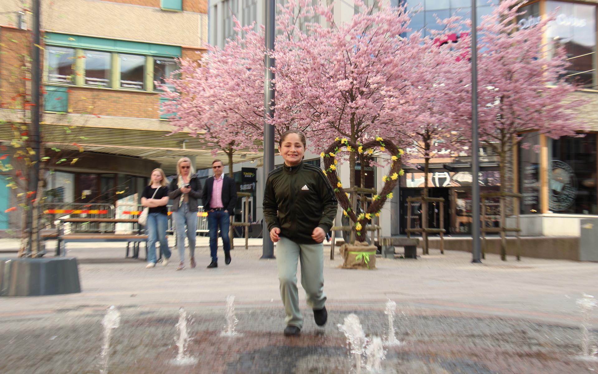 Liyana Elsalhe springer genom fontänen och försöker undvika vattenstrålarna. 