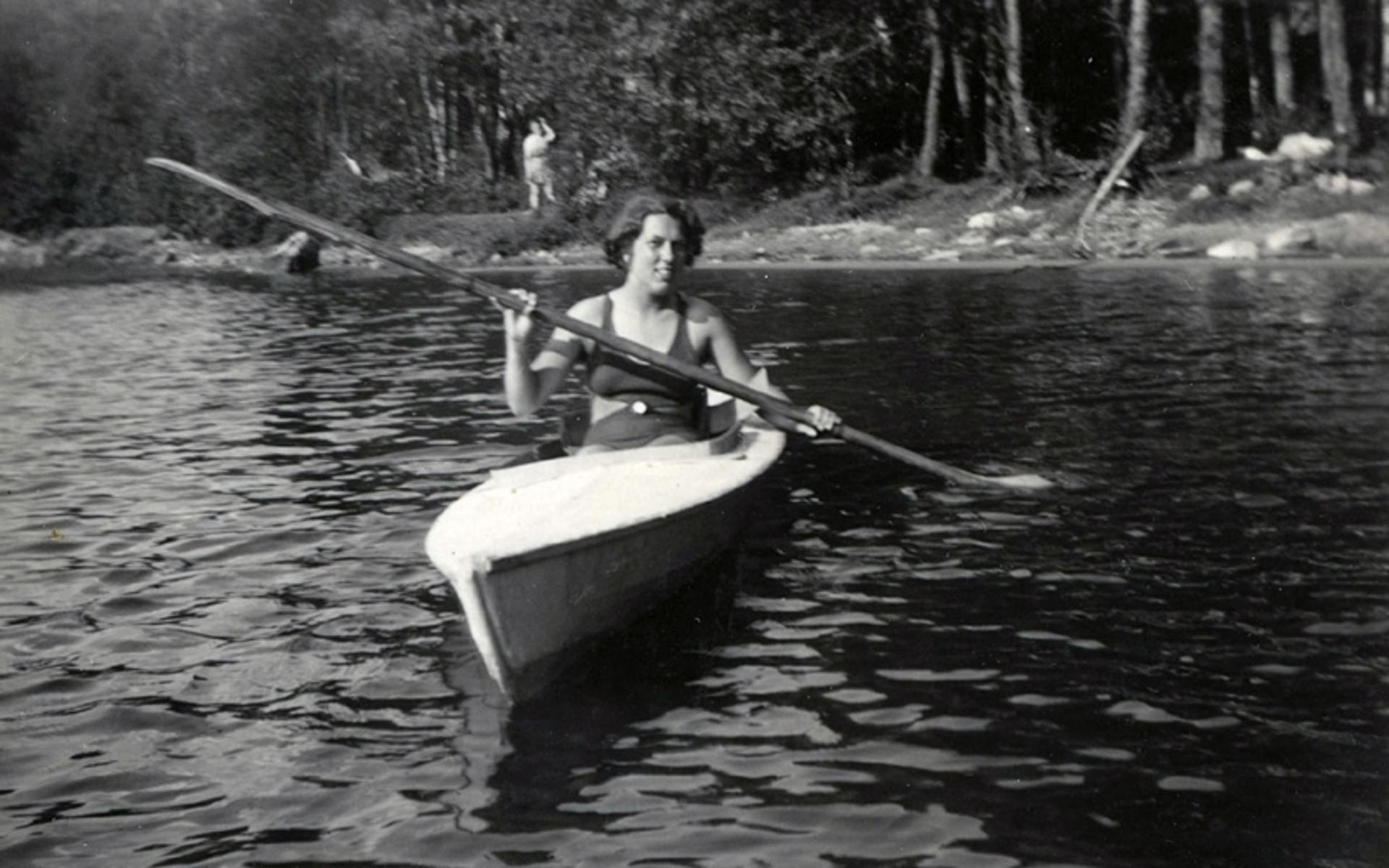 Sommargästen Eivor Dahlberg vid en av stränderna vid Tulebo Strandväg. Ser lite osäkert ut… Kanske första gången i kanot? Cirka 1935.
