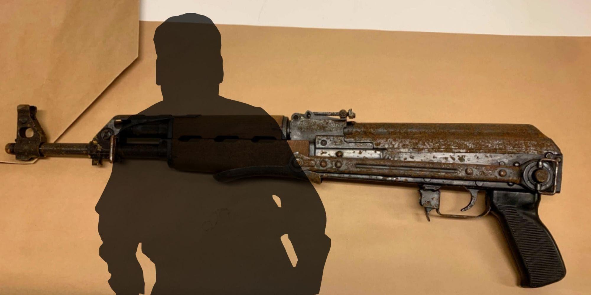 Ett gevär ligger på ett bord. Framför är en mörk siluett av en man inklippt.
