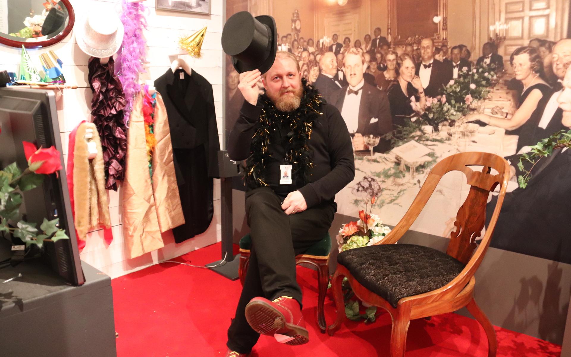 Museichefen Karl Arvidsson provar fotohörnan. Här kan man ta på sig festliga kläder och knäppa en bild på sig själv. 