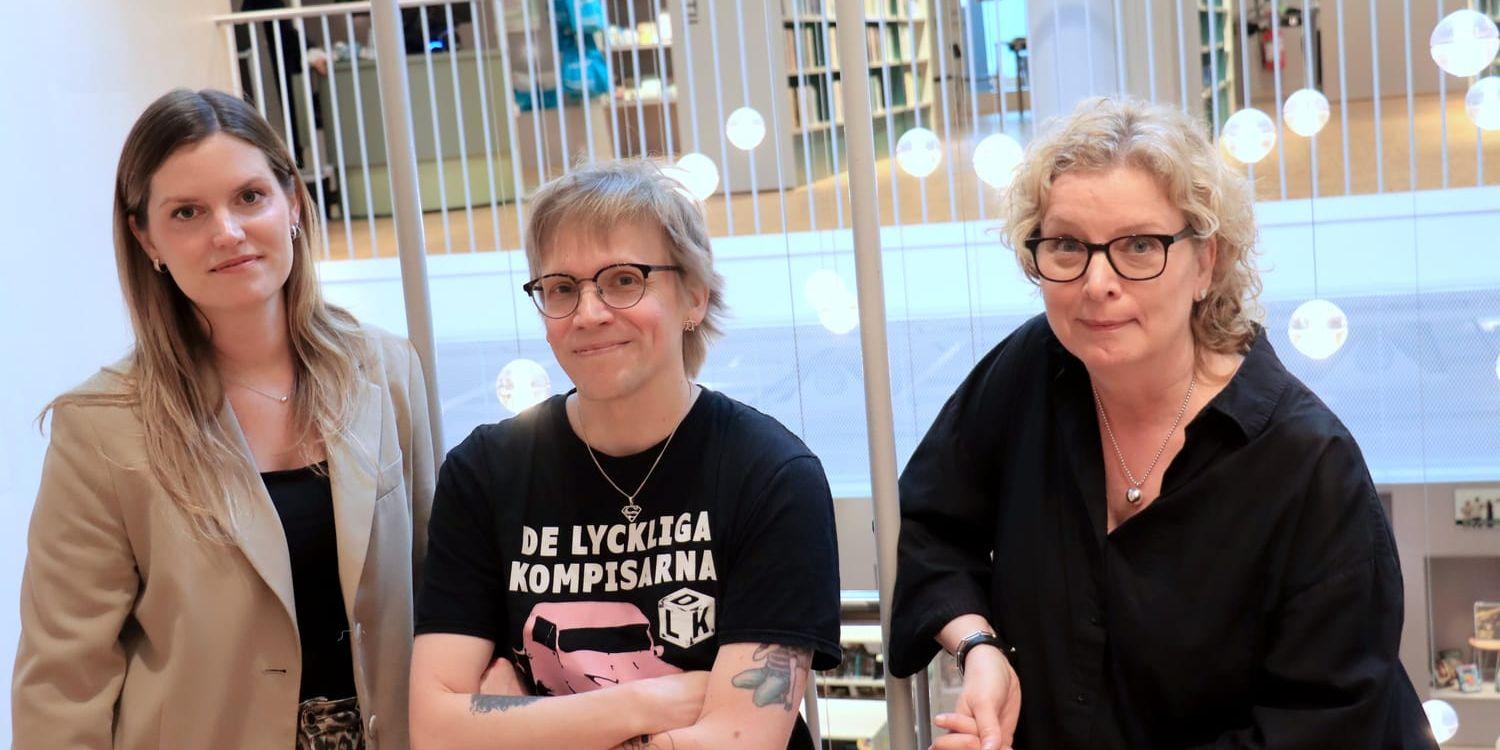 En kvinna, en man och en kvinna bredvid varandra, med lampor i bakgrunden.