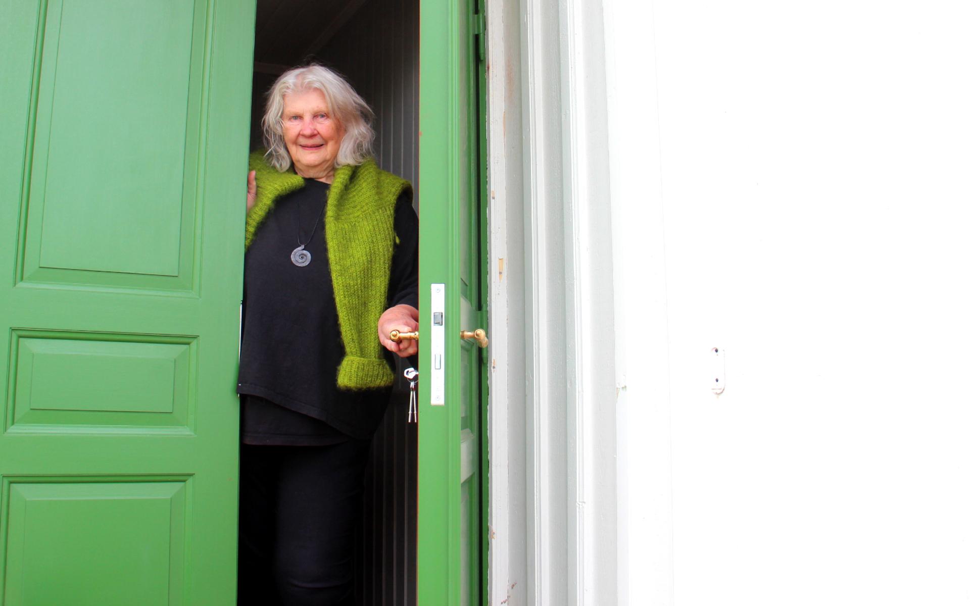 Karin Berglund välkomnar in i den vita villan med den gröna dörren. ”Jag är väldigt glad i min nya dörr”, säger hon.